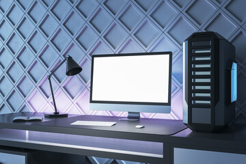 Creative gamers desktop with empty white computer screen, lamp and system unit on decorative blue wall backdrop. Gaming concept. Mock up, 3D Rendering.