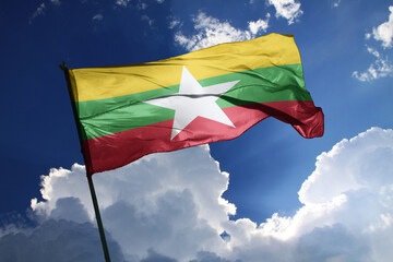 national flag of Myanmar waving in the wind on a clear day.