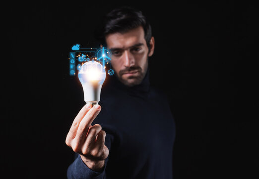 Man exhibiting new ideas in technology and creativity while holding lightbulbs. concept innovation using sparkly lightbulbs.