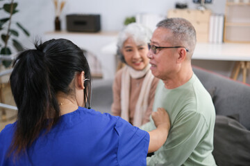 Attentive doctor or healthcare worker giving professional advice to senior couple during home visit