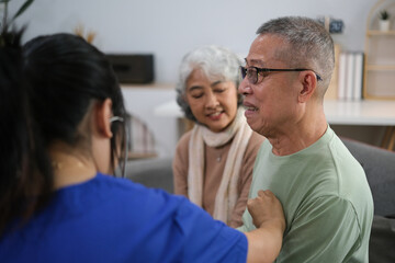Attentive doctor or healthcare worker giving professional advice to senior couple during home visit