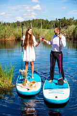 Couple have picnic on stand up paddle board in the lake, SUP