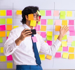 Young employee in conflicting priorities concept