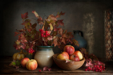 Still life with applles and scarlet viburnum autumn branches and berries in vintage style.