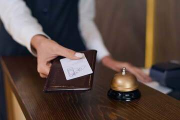 Close-up of receptionist giving passport and key from the room in the hotel