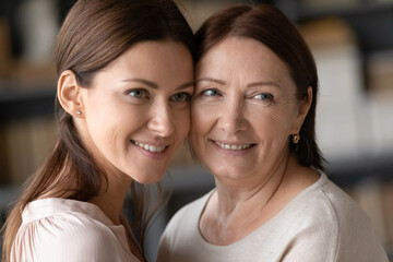 Close up faces of beautiful similar women different ages and generations females, middle-aged...
