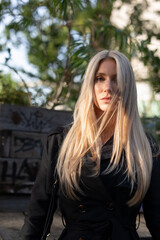 Naklejka premium Blond wonderful woman with black dress in autum dance in the wind