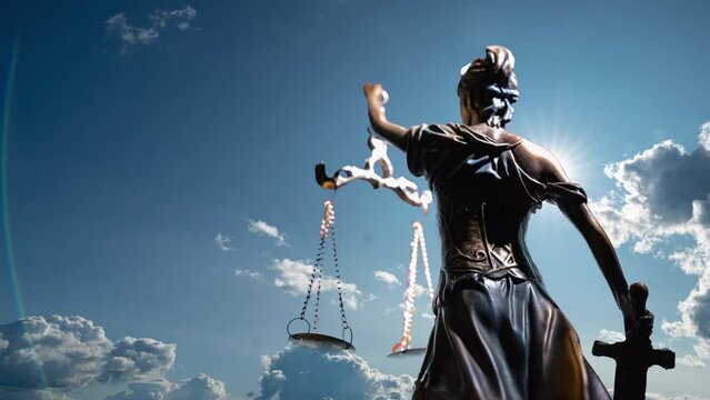 the statue of justice turns against the backdrop of clouds moving across the blue sky. time lapse 4k.