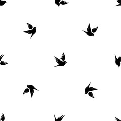 Seamless pattern of repeated black bird symbols. Elements are evenly spaced and some are rotated. Vector illustration on white background
