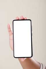 Front view of blank screen smartphone in hand on grey background