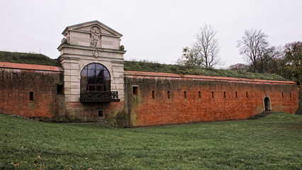 Old Lublin gate (Brama Lubelska) of fortress in Zamosc, Poland. Ancient fortification brick wall. - obrazy, fototapety, plakaty