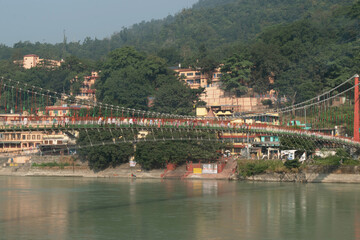 Fototapeta premium Beautiful view of ram jhula with ganga river and mountains in rishikesh, uttarakhand