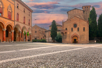 Piazza Santo Stefano. View of the facade of basilica and people walking or standing in the square....