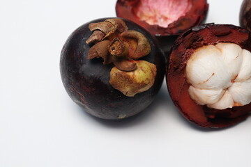 Fototapeta premium Fresh ripe mangosteen fruit, white on the inside and brown or purple on the outside. The taste is sweet and refreshing. Isolated white background.