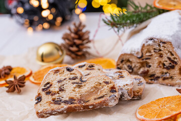 Christmas stollen on wooden background. Traditional christmas german dessert cut into pieces. Cake with nuts, raisins with marzipan and dried fruit on cutting board. baking for xmas