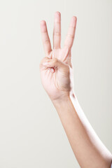 Fototapeta premium Hand showing three gesture isolated on grey background