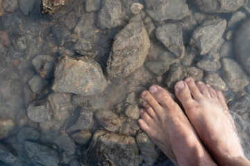 Top view of foot in water and stone, relax feeling