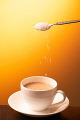 Sugar pouring in tea cup