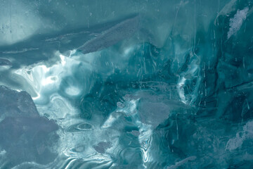 The thickness of green-blue ice through which light is visible. Texture of frozen ice of a mountain lake