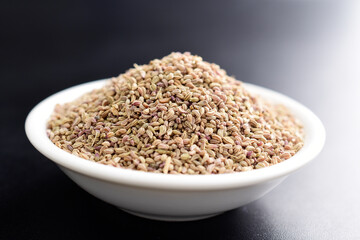 Closeup of ajwain in bowl on dark background