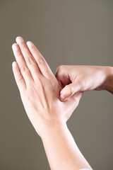 Arthritis pain in hand on grey background