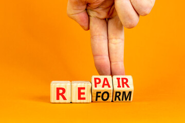 Reform and repair symbol. Concept words Reform Repair on wooden block. Beautiful orange table...