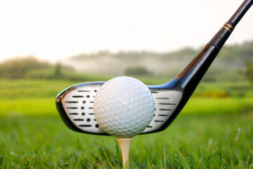 Golf ball set on tee and club head 1 mountain background.