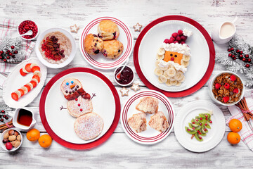 Christmas breakfast table scene. Top down view on a white wood background. Fun holiday food...