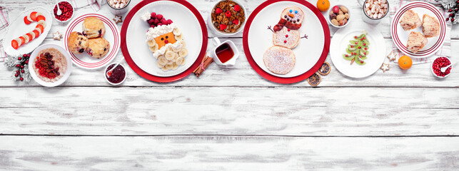 Christmas breakfast top border. Above view on a white wood banner background. Fun holiday food...