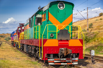 The steam green train is in the middle of an old railway. the concept of the transport, travel, transport