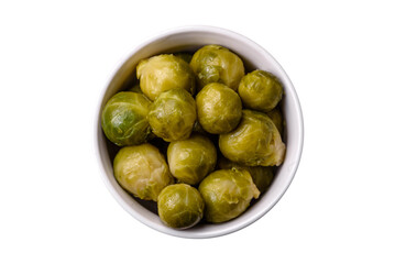 Delicious boiled Brussels sprouts on a ceramic plate on a dark concrete background