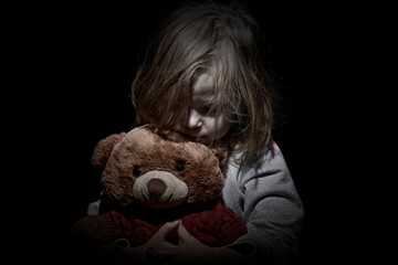 Sad little girl embracing her teddy bear - feels lonely - if you are small girl teddy bear is willing to be your best friend - vintage filter applied - obrazy, fototapety, plakaty