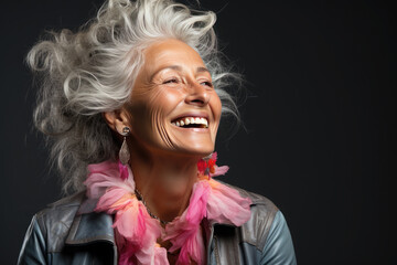 Portrait of happy glamorous senior woman on a black background.Energetic Grandma with hairstyle in stylish outfit.