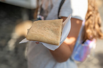 a child holding a crepe on a napkin