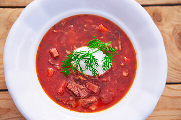 Close up picture of the rustic style deep plate full of borsch soup, traditional delicacy of eastern european cuisine like Ukraine or Russia. Satisfying dish served like main course with rye bread.