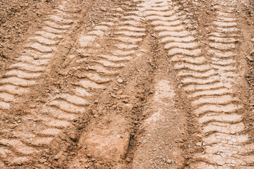 Texture of traces on the ground from the tread of trucks and tractors at a construction site,...