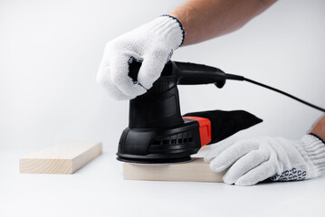 Eccentric grinding machine in hands. Power tool. On a white background. The master of wood blocks...