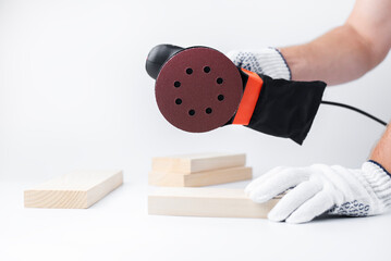 Eccentric grinding machine in hands. Power tool. On a white background. The master of grinding wood...