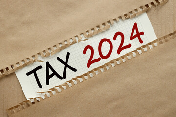 text on torn paper. craft background. words Tax 2024