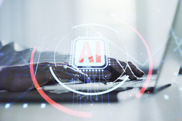 Double exposure of creative artificial Intelligence abbreviation with hand typing on computer...