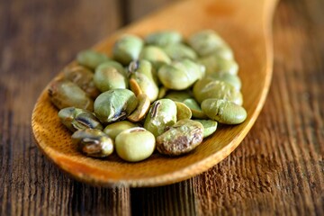 4K Image: Close-Up of Roasted Edamame (Roasted Soybeans) on a Wooden Spoon, Table Setting