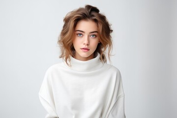 Obraz premium A thoughtful, attractive young Caucasian woman with curly brunette hair in a stylish studio portrait.