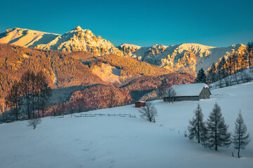 Winter scenery with snow covered high mountains at sunset