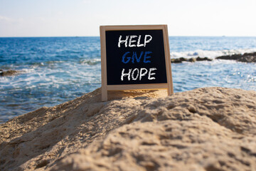 Help Give Hope symbol. Concept words Help Give Hope on chalk blackboard. Beautiful sea background. Business and Help Give Hope concept. Copy space.