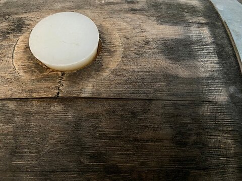 bung hole in wooden barrel with rubber bung cork in hole used for aging wine ales or spirits background 