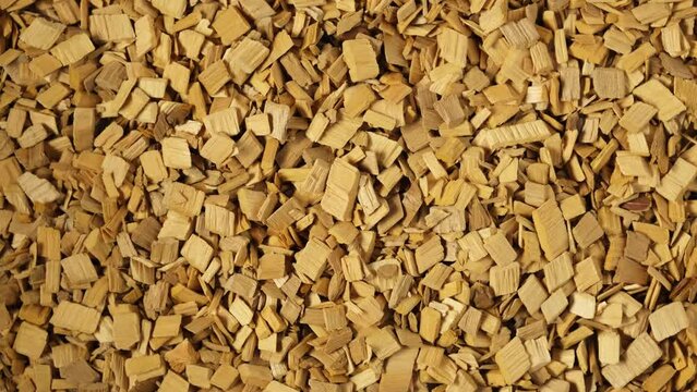 Wood chips for barbecue, close-up. Video 4K, clockwise Rotation. Hardwood alder chips for food smoking. Splinter sliver for grill made of alder wood.