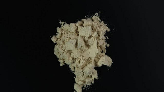 Soy protein concentrate, isolated from soybean on dark background, top view. Pure Whey Protein. Video, 4K. Rotating. Food additive, ingredient for fitness cocktail or smoothie.