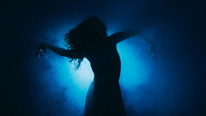 Contemporary choreography. Sensual dance. Woman expressive body silhouette moving in dark mist...