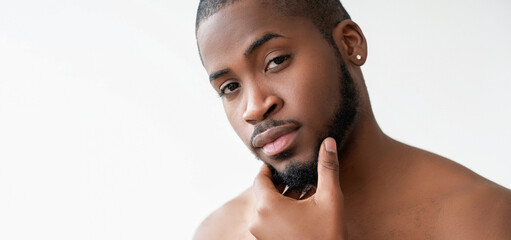 Beard care. Metrosexual lifestyle. Confident satisfied handsome shirtless man touching face skin...