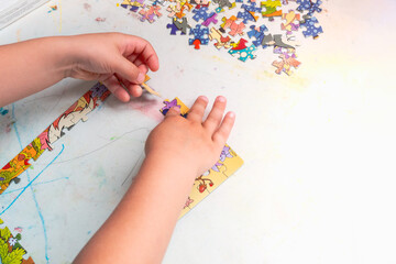 A small baby collects a mosaic puzzle game for the development of children's creativity